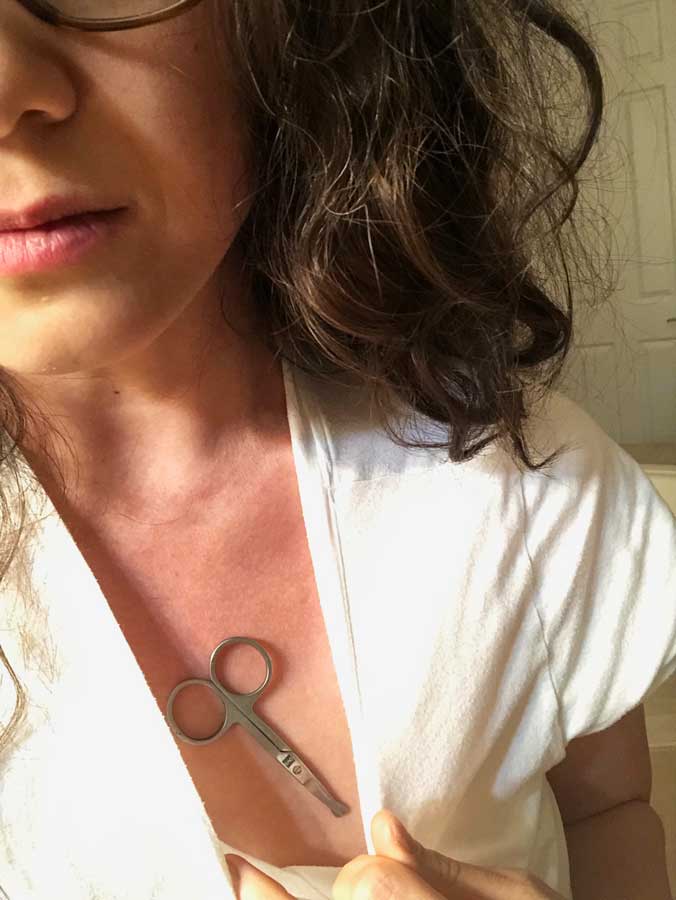 Woman with small scissor magnetized to her chest